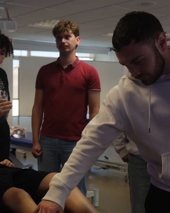Estudiantes de fisioterapia practican la palpación en una clase presencial