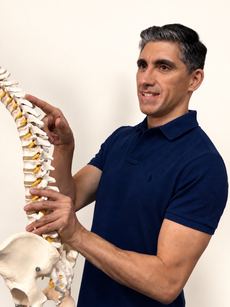 Daniel Torres, fisioterapeuta, explica la columna vertebral sobre un modelo anatómico
